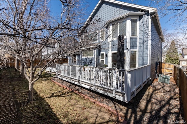 view of side of home with a wooden deck and fence