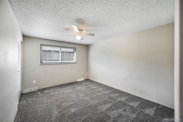 carpeted spare room featuring visible vents, a textured ceiling, and ceiling fan