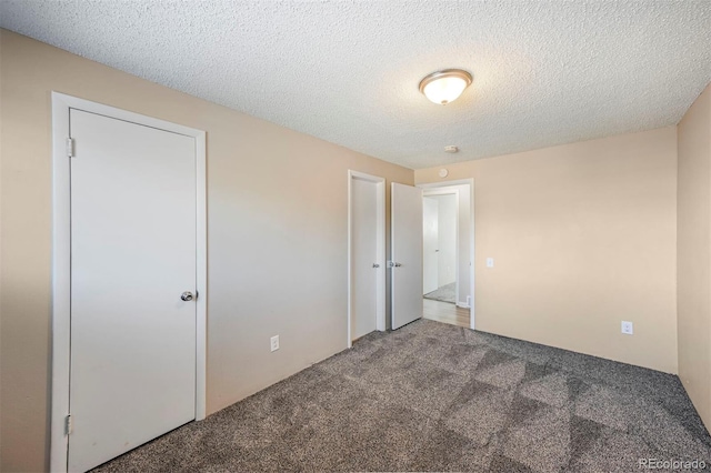 unfurnished bedroom with a textured ceiling and carpet flooring