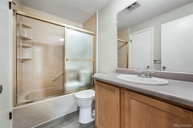 full bathroom featuring visible vents, combined bath / shower with glass door, toilet, and vanity