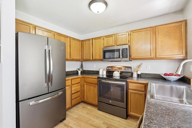 8510 Union Cir, Arvada, CO 80005 - kitchen featuring appliances with stainless steel finishes, dark countertops, and light wood-style floors