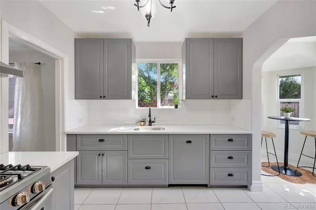 kitchen with gray cabinetry, decorative backsplash, sink, and light tile patterned floors