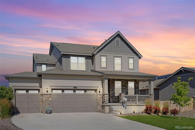 1061 S De Gaulle Ct, Aurora, CO 80018 - view of front of property featuring covered porch, board and batten siding, concrete driveway, and stone siding