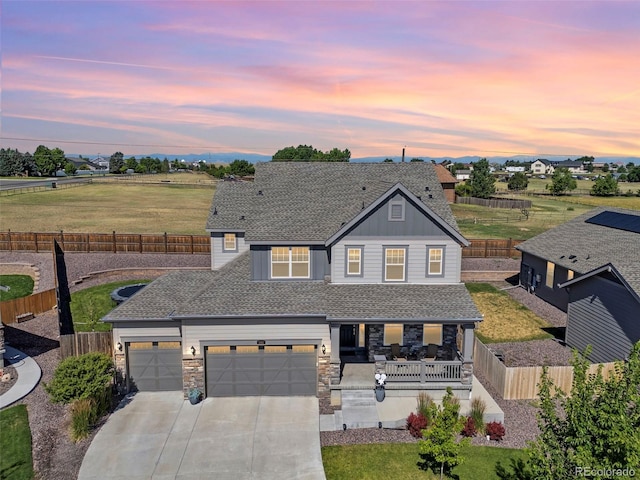 1061 S De Gaulle Ct, Aurora, CO 80018 - view of front of home featuring a porch, concrete driveway, a fenced backyard, a garage, and a shingled roof