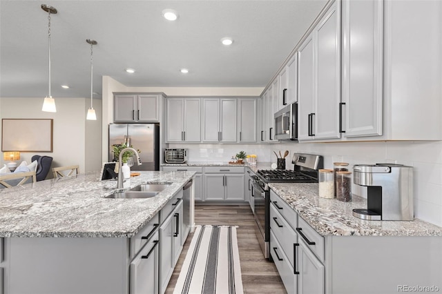 1061 S De Gaulle Ct, Aurora, CO 80018 - kitchen with stainless steel appliances, gray cabinets, light wood-style floors, an island with sink, and recessed lighting