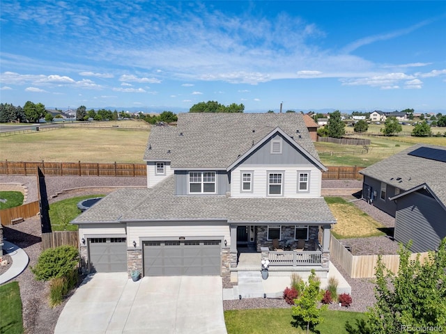 1061 S De Gaulle Ct, Aurora, CO 80018 - view of front facade featuring a porch, driveway, stone siding, an attached garage, and board and batten siding