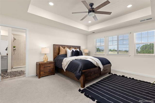 1061 S De Gaulle Ct, Aurora, CO 80018 - bedroom featuring a tray ceiling, light colored carpet, recessed lighting, ensuite bath, and ceiling fan
