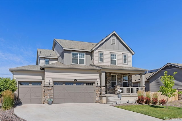 1061 S De Gaulle Ct, Aurora, CO 80018 - view of front of property featuring covered porch, driveway, stone siding, board and batten siding, and an attached garage
