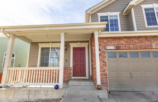 property entrance with an attached garage, covered porch, and brick siding