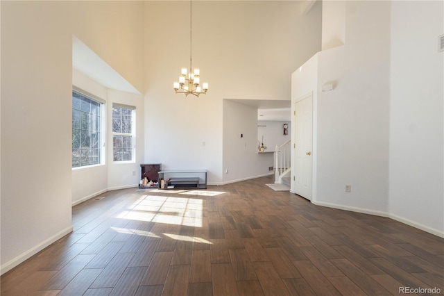 interior space with dark wood-style floors, stairway, baseboards, and an inviting chandelier