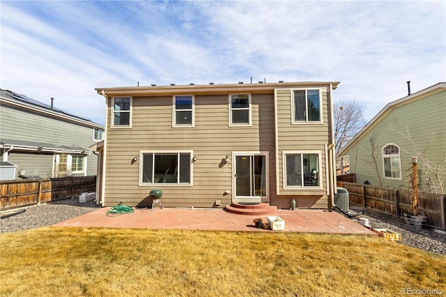 back of property with a yard, a fenced backyard, central AC unit, and a patio