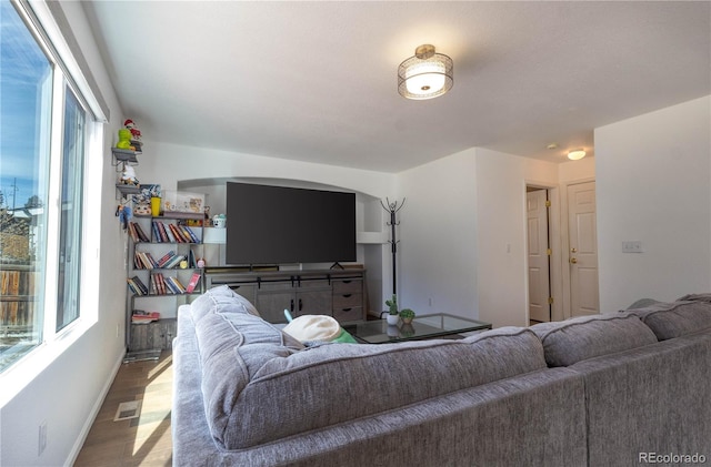 living room featuring light wood finished floors, baseboards, and visible vents