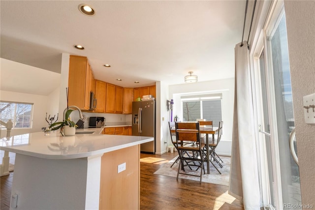 kitchen featuring recessed lighting, stainless steel appliances, dark wood-type flooring, a peninsula, and light countertops