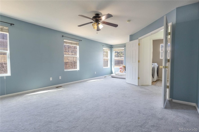 unfurnished bedroom with ceiling fan, separate washer and dryer, carpet, and baseboards