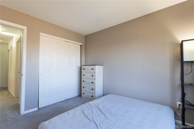 bedroom with a closet, carpet flooring, and baseboards