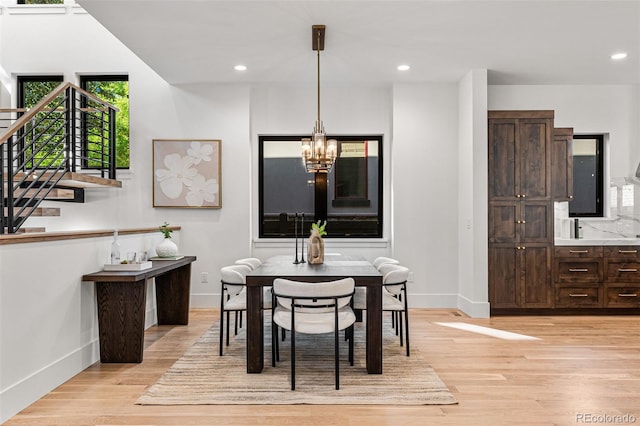 dining area featuring light hardwood / wood-style floors and a chandelier