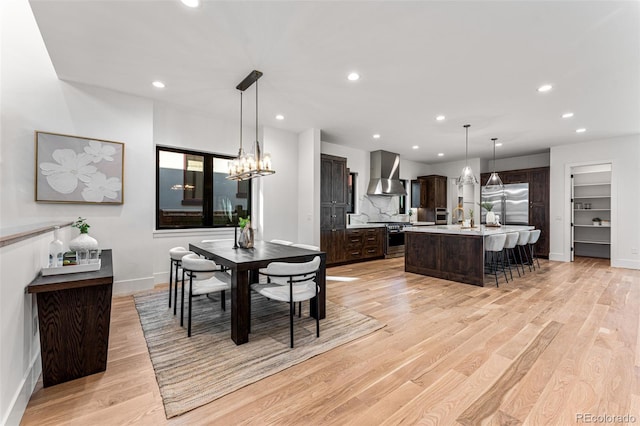 dining space featuring a notable chandelier and light wood-type flooring