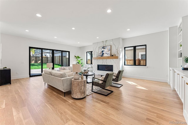 living room with light hardwood / wood-style floors and a high end fireplace