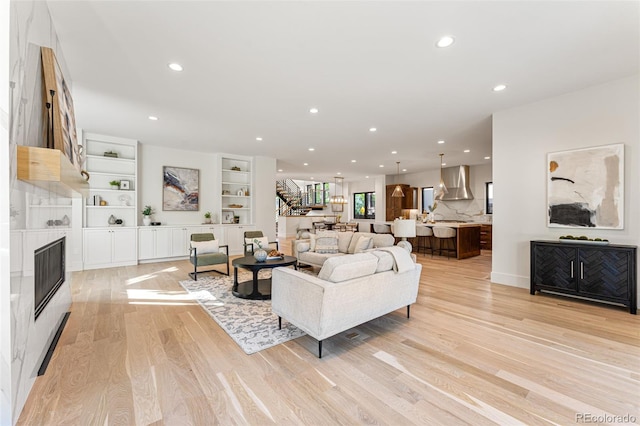 living room featuring light hardwood / wood-style flooring and built in shelves