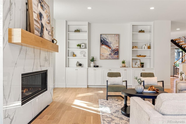 living room featuring a tile fireplace and light hardwood / wood-style flooring