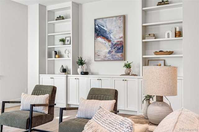 living area featuring light hardwood / wood-style floors and built in shelves