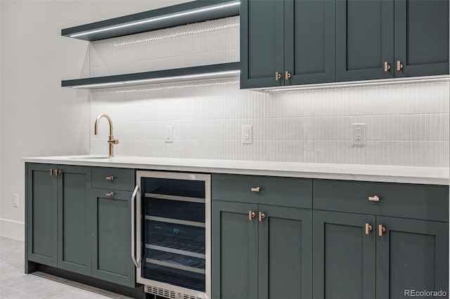 bar with decorative backsplash, beverage cooler, light tile patterned floors, and sink