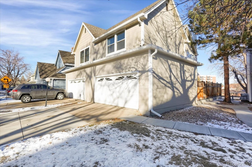 snow covered property with a garage