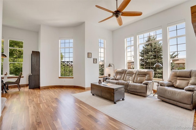 living room with light wood-type flooring and ceiling fan