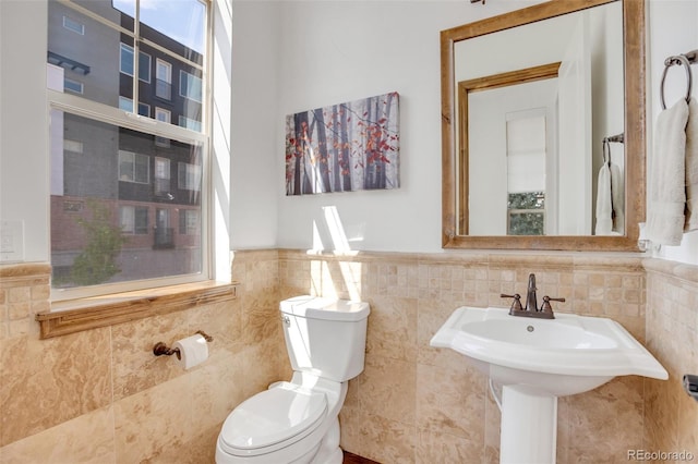 bathroom featuring tile walls and toilet