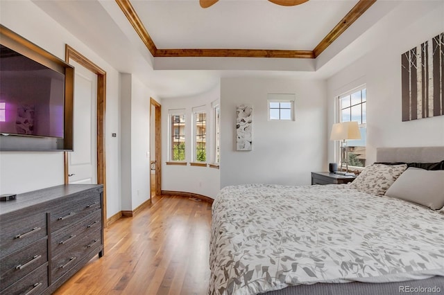 bedroom with ceiling fan, multiple windows, and a raised ceiling