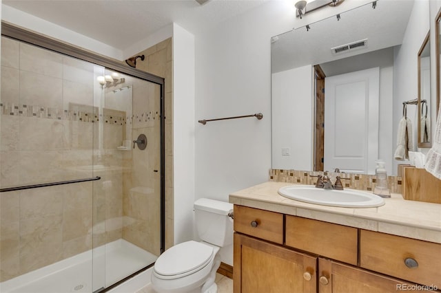 bathroom featuring toilet, an enclosed shower, vanity, and a textured ceiling