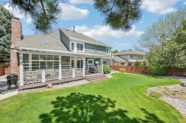 rear view of property with a wooden deck, a chimney, and a shingled roof