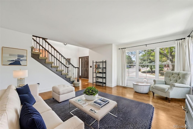living room featuring wood finished floors and stairway