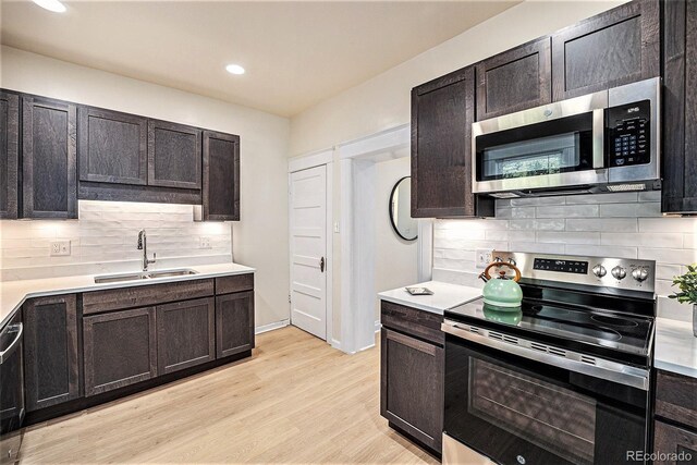 1021 E 23rd Ave, Denver, CO 80205 - kitchen with appliances with stainless steel finishes, tasteful backsplash, light countertops, light wood-style floors, and recessed lighting
