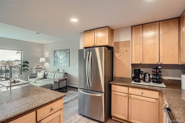 kitchen featuring recessed lighting, light brown cabinets, freestanding refrigerator, a baseboard radiator, and open floor plan