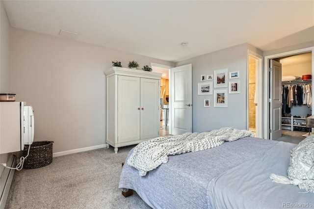carpeted bedroom featuring baseboards, a closet, and a walk in closet