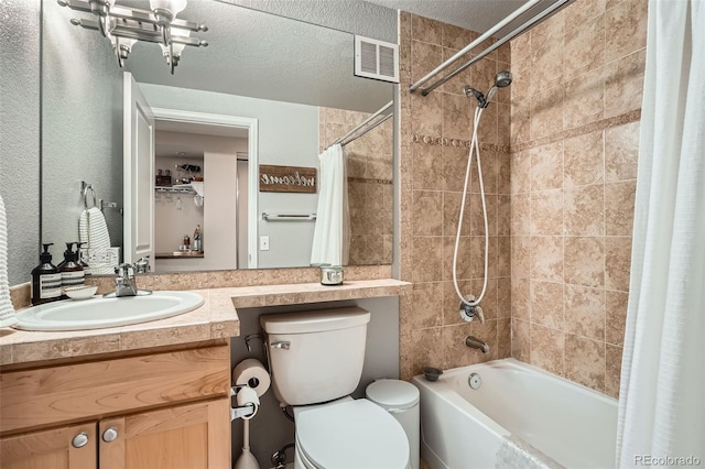 bathroom featuring a textured ceiling, vanity, shower / bath combination with curtain, toilet, and visible vents