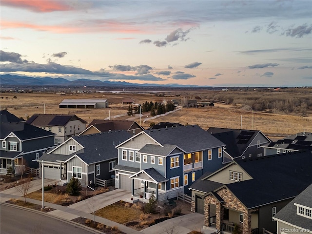 aerial view at dusk featuring a residential view and a mountain view