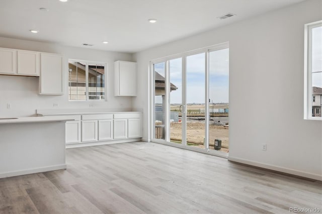 6646 N Nepal St, Aurora, CO 80019 - kitchen featuring light wood-style flooring, white cabinetry, recessed lighting, and baseboards