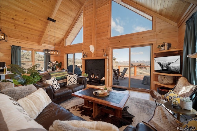 577 Gcr 8952, Granby, CO 80446 - living room with wood walls, hardwood / wood-style flooring, a wooden ceiling with exposed beams, high vaulted ceiling, and a lit fireplace