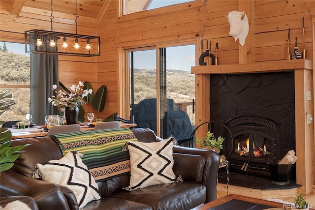 577 Gcr 8952, Granby, CO 80446 - living room with wooden walls, plenty of natural light, vaulted ceiling, a warm lit fireplace, and wood ceiling