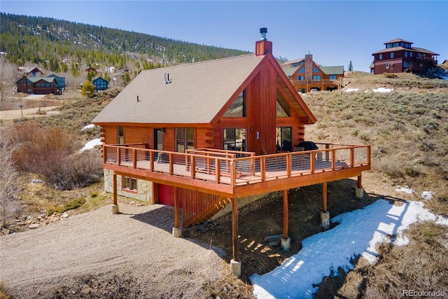 577 Gcr 8952, Granby, CO 80446 - back of property with log exterior, a wooden deck, a chimney, and stone siding