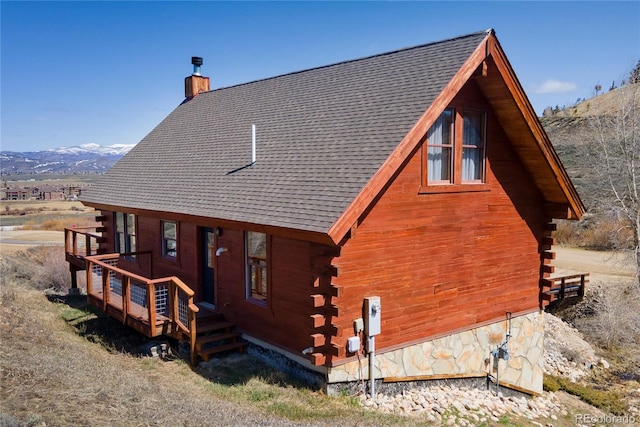 577 Gcr 8952, Granby, CO 80446 - view of side of property with log exterior, a chimney, a shingled roof, and a deck with mountain view
