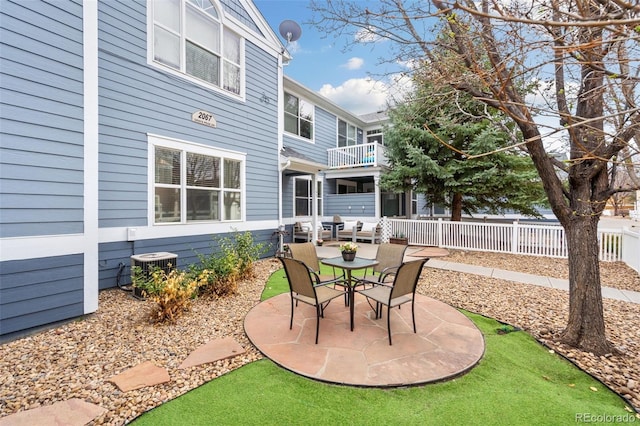 view of patio / terrace with cooling unit, a balcony, and fence