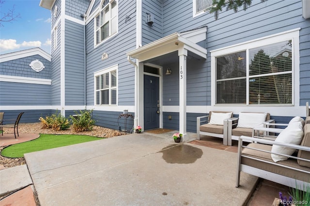 view of exterior entry with a wall unit AC and a patio area