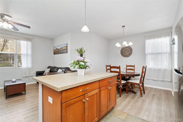 kitchen featuring light countertops, a center island, light wood finished floors, and pendant lighting