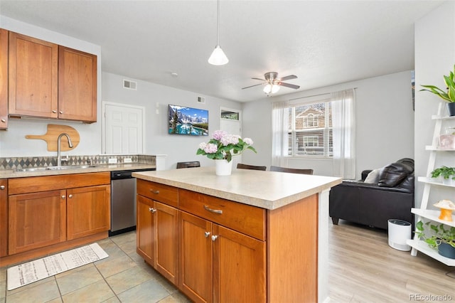 kitchen featuring visible vents, a sink, ceiling fan, light countertops, and stainless steel dishwasher