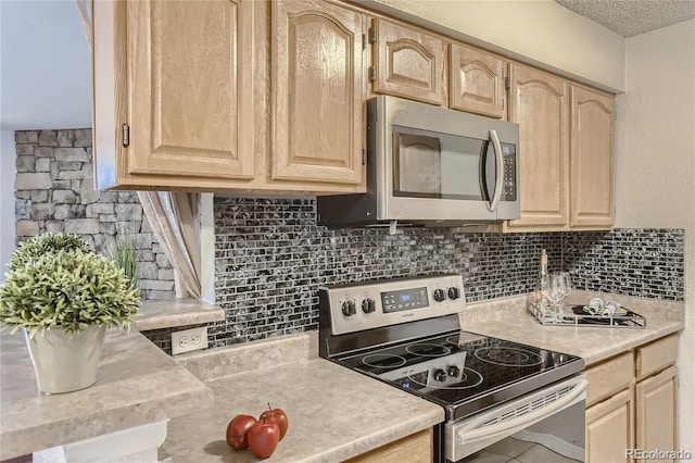 kitchen featuring backsplash, light brown cabinetry, and stainless steel appliances