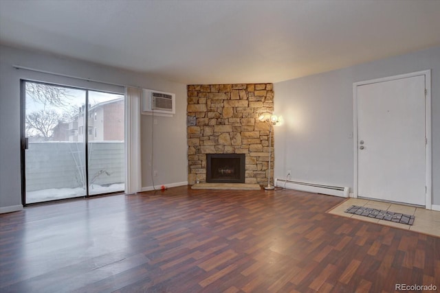 unfurnished living room featuring a fireplace, an AC wall unit, baseboard heating, and dark wood-type flooring