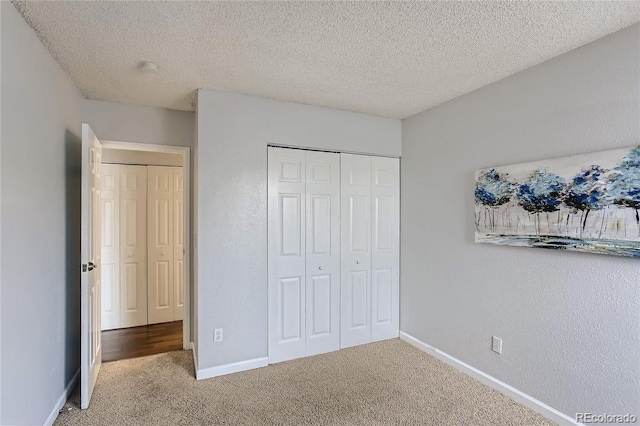 unfurnished bedroom featuring carpet flooring, a textured ceiling, and a closet